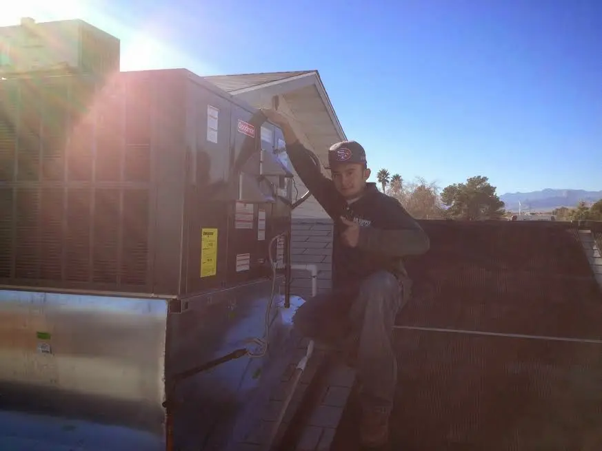 HVAC technician performing AC Tune-Up on a rooftop unit in Bee Ridge